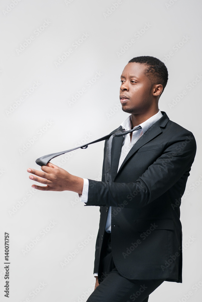 Office worker puppet unable to express opinion and will. African american employee on grey background with free space. Office worker puppet unable to express opinion and will. African american employee on grey background with free space.