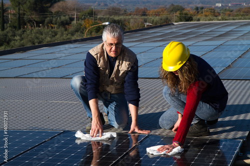 young girl and elderly man cleaning photovoltaic panels