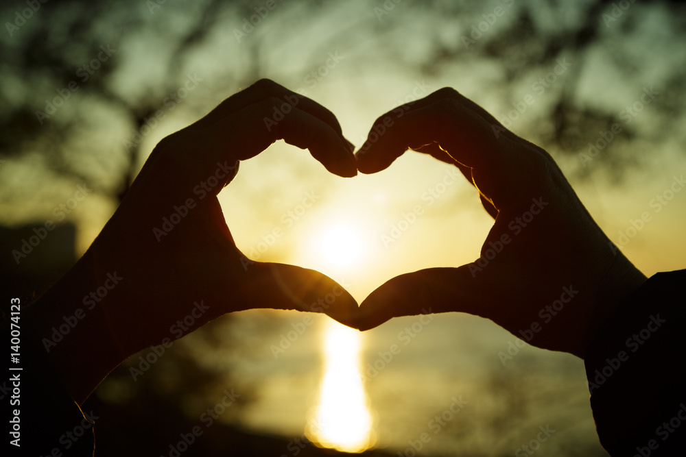 Heart from the combined hands against a sunset Heart from the combined hands against a sunset