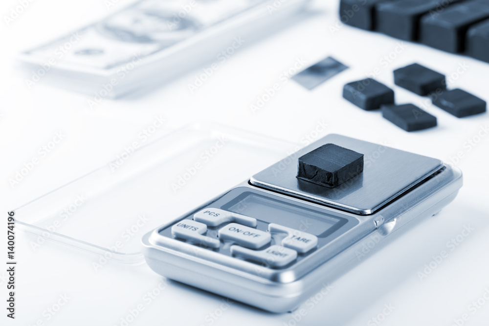 Blocks of hashish on digital scales over white background Blocks of hashish on digital scales over white background