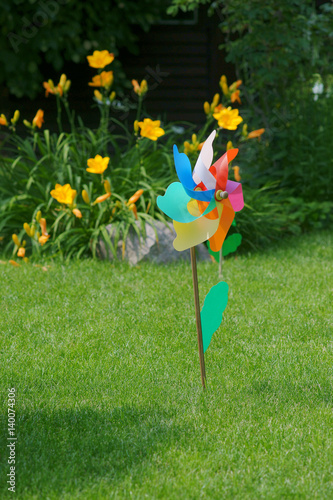 Children's pinwheel on the lawn in the garden photo