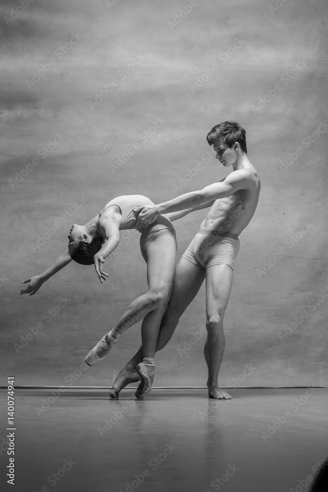 Obraz premium Couple of ballet dancers posing over gray background