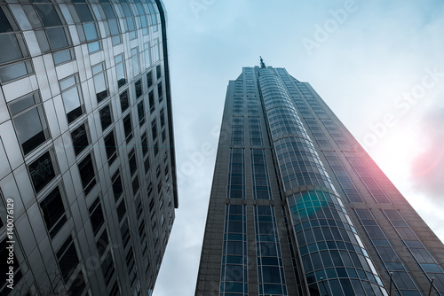 Bottom view of skyscrapers with lens flare filter effect