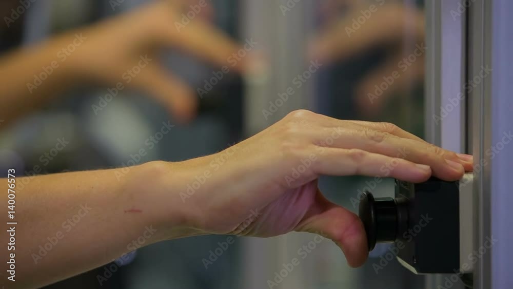 A woman is pushing two black buttons and is holding them for a few moments. Something goes down.
A woman is pushing two black buttons and is holding them for a few moments. Something goes down.