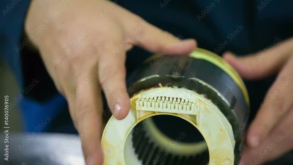 A man is using a knife to check something on the top of the wire. Then he places the item somewhere else.
A man is using a knife to check something on the top of the wire. Then he places the item somewhere else.