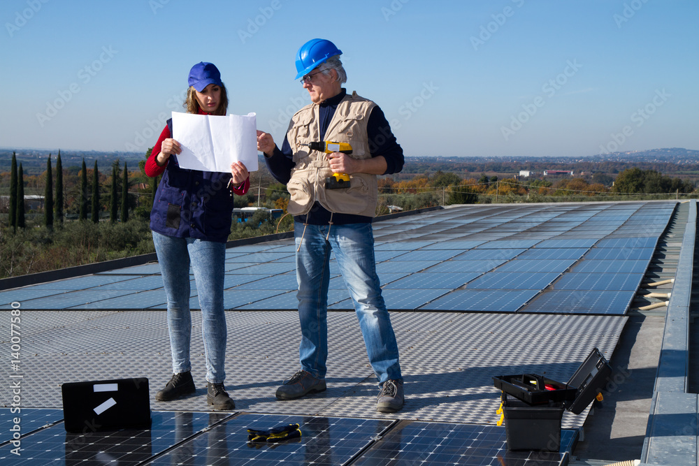 young engineer girl and an elderly skilled worker fitting a photovoltaic plant young engineer girl and an elderly skilled worker fitting a photovoltaic plant