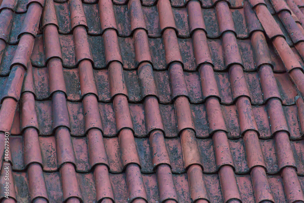 Old tile roof terracotta red color on house background base of natural stone Old tile roof terracotta red color on house background base of natural stone