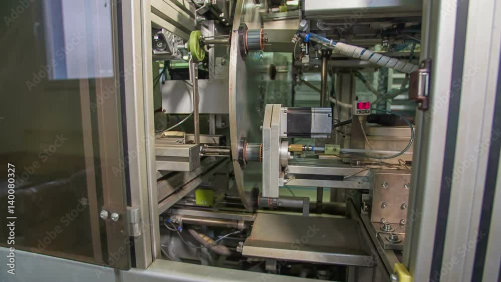 We can see the production of the particles in a factory. There is a lot of equipment and wires everywhere.
