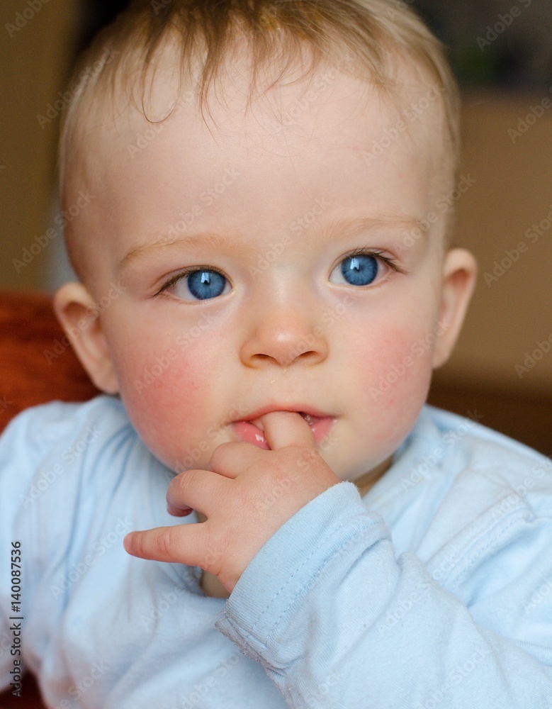 Close-up portrait of toddler sucking his finger. Beautiful boy has blue expressive eyes. Child concept. Close-up portrait of toddler sucking his finger. Beautiful boy has blue expressive eyes. Child concept.