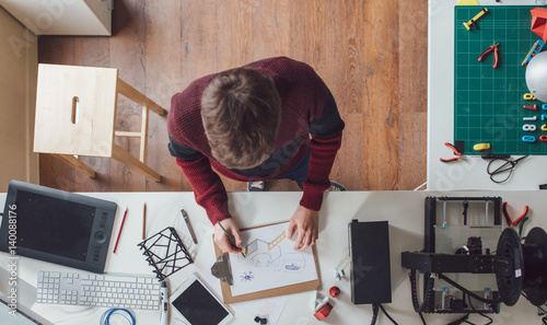 Overhead photo of graphic designer drawing a sketch for 3d printing. photo