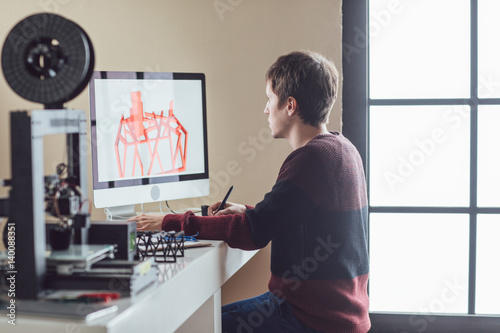 Young Caucasian man designing object for 3d printing.