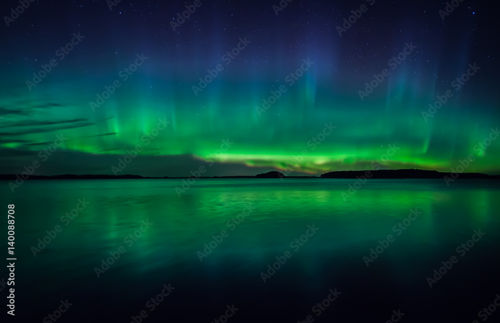 Northern lights dancing over calm lake 