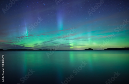 Northern lights dancing over calm lake  © Conny Sjostrom
