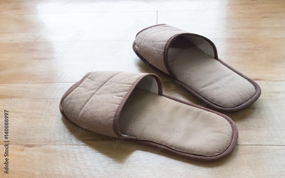 Brown house slippers on wood floor, relax concept Brown house slippers on wood floor, relax concept