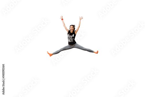 Attractive excited fitness girl in sportwear jumping trampoline isolated on white background