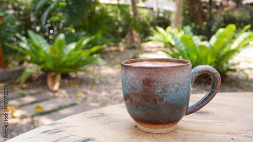 Coffee cup on wooden table in the garden