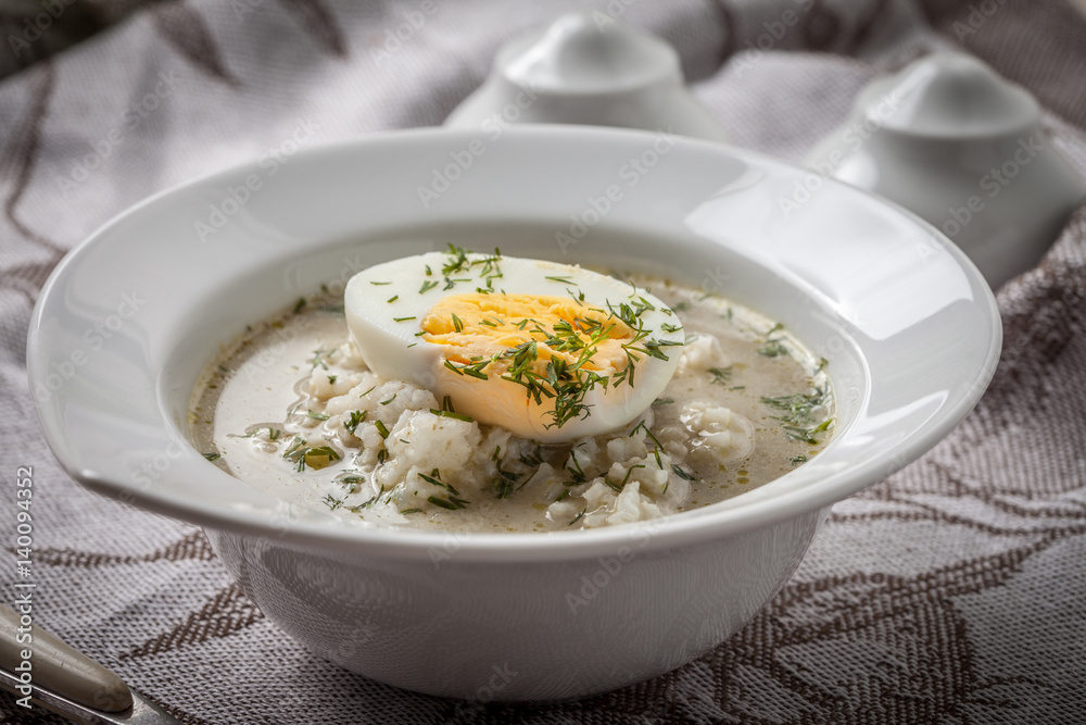 Sorrel soup with egg in white bowl.