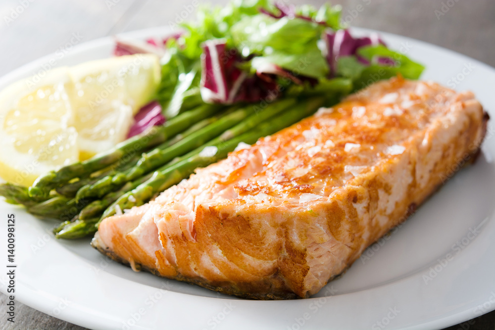 Grilled salmon fillet with asparagus and salad in plate on wooden table
Grilled salmon fillet with asparagus and salad in plate on wooden table