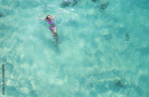 woman swimming in the sea in aerial view