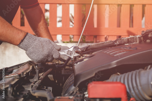 Technician checking or fixing engine of modern car