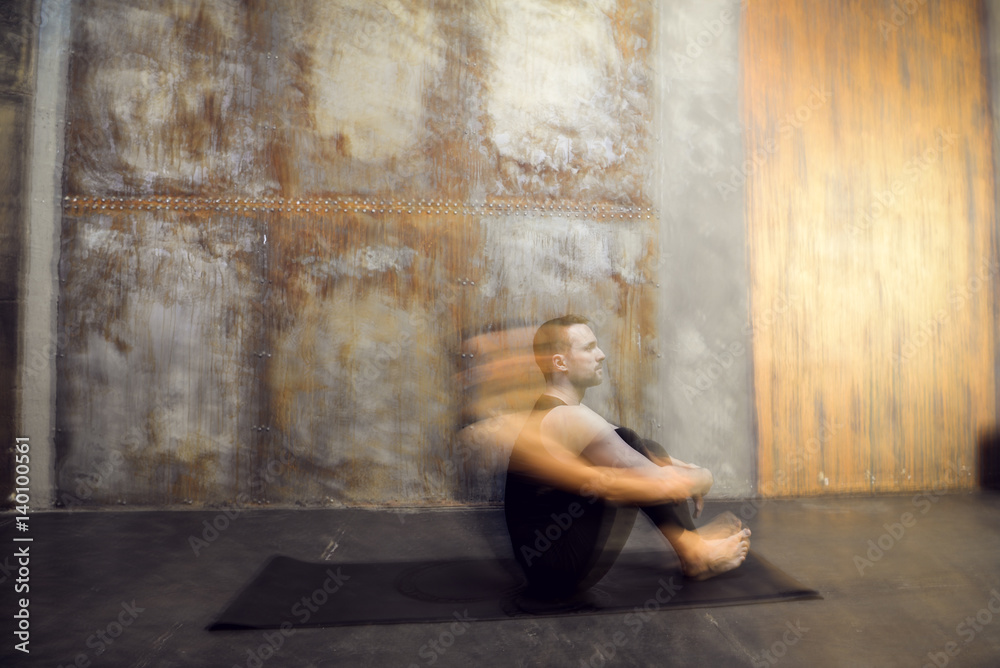 Young athletic man practicing acroyoga. Balancing . Fit active pair yoga time. Sporty handsome man. Training time. Asana 