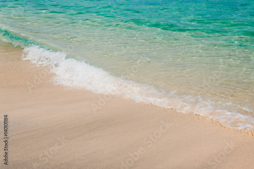 Peaceful beach background. White sand and turquoise sea water. Ocean coastline of nice sand and calm waves. Tropical vacation concept.