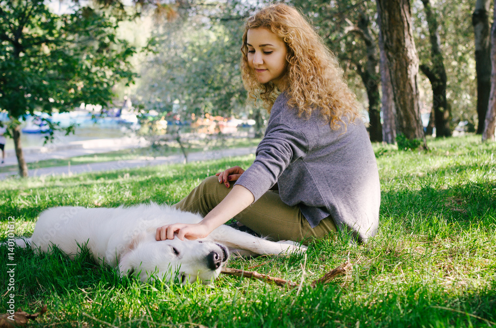 Young female playing with labrador retriever dog in park Young female playing with labrador retriever dog in park