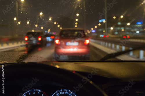 Driving a car in a bad weather, in traffic jam
