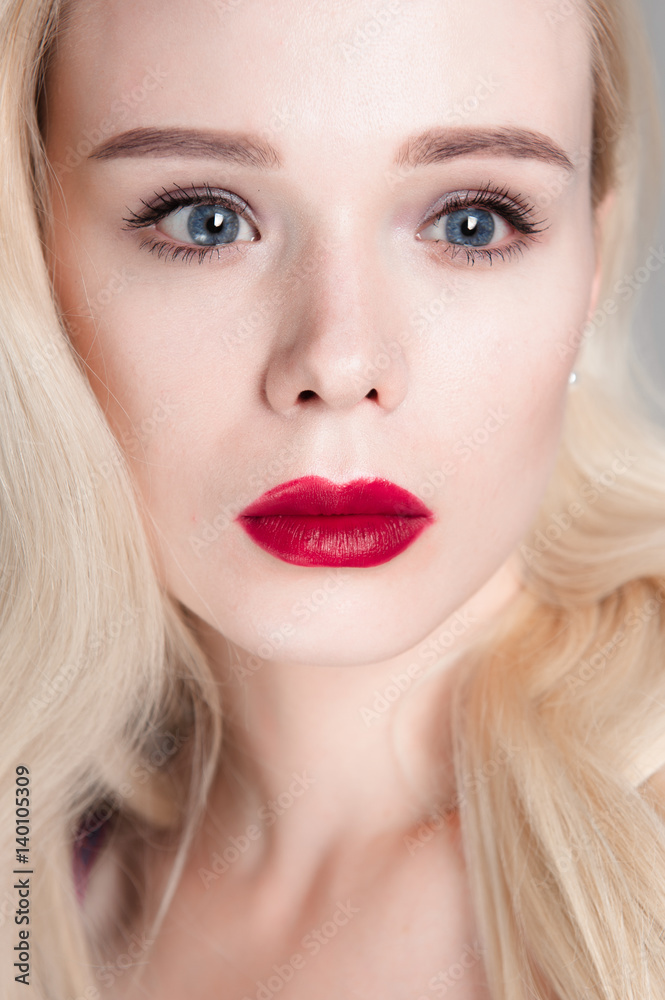 Beauty model girl with perfect make-up red lips and blue eyes looking at camera. Portrait of attractive young woman with blond hair. Beautiful female face with clear fresh skin. Fashion close up shot. Beauty model girl with perfect make-up red lips and blue eyes looking at camera. Portrait of attractive young woman with blond hair. Beautiful female face with clear fresh skin. Fashion close up shot.