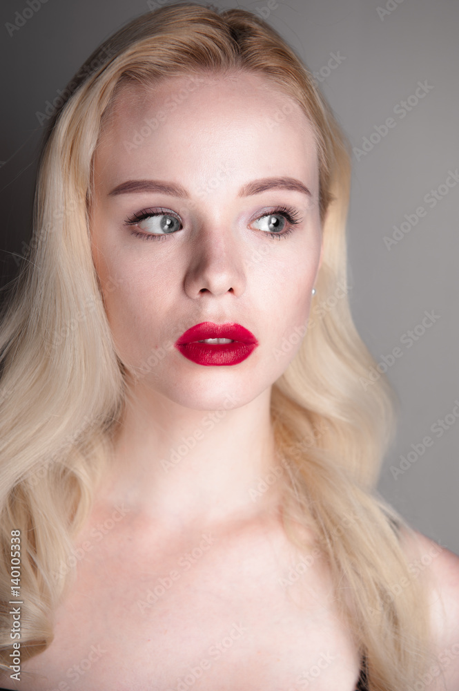 Beauty model girl with perfect make-up red lips and blue eyes looking at camera. Portrait of attractive young woman with blond hair. Beautiful female face with clear fresh skin. Fashion close up shot. Beauty model girl with perfect make-up red lips and blue eyes looking at camera. Portrait of attractive young woman with blond hair. Beautiful female face with clear fresh skin. Fashion close up shot.