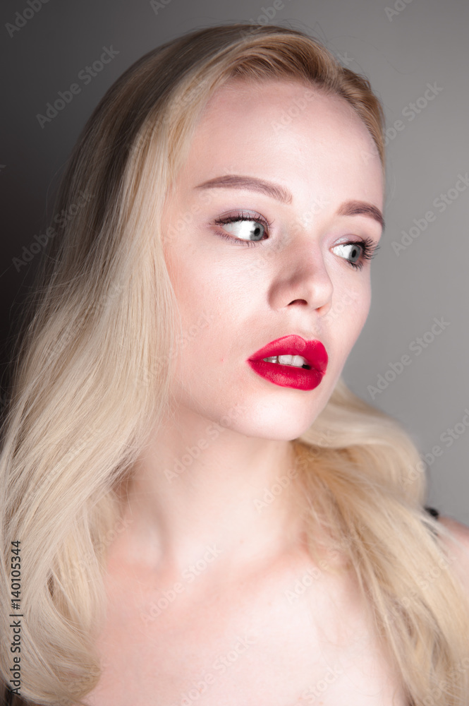 Beauty model girl with perfect make-up red lips and blue eyes looking at camera. Portrait of attractive young woman with blond hair. Beautiful female face with clear fresh skin. Fashion close up shot. Beauty model girl with perfect make-up red lips and blue eyes looking at camera. Portrait of attractive young woman with blond hair. Beautiful female face with clear fresh skin. Fashion close up shot.