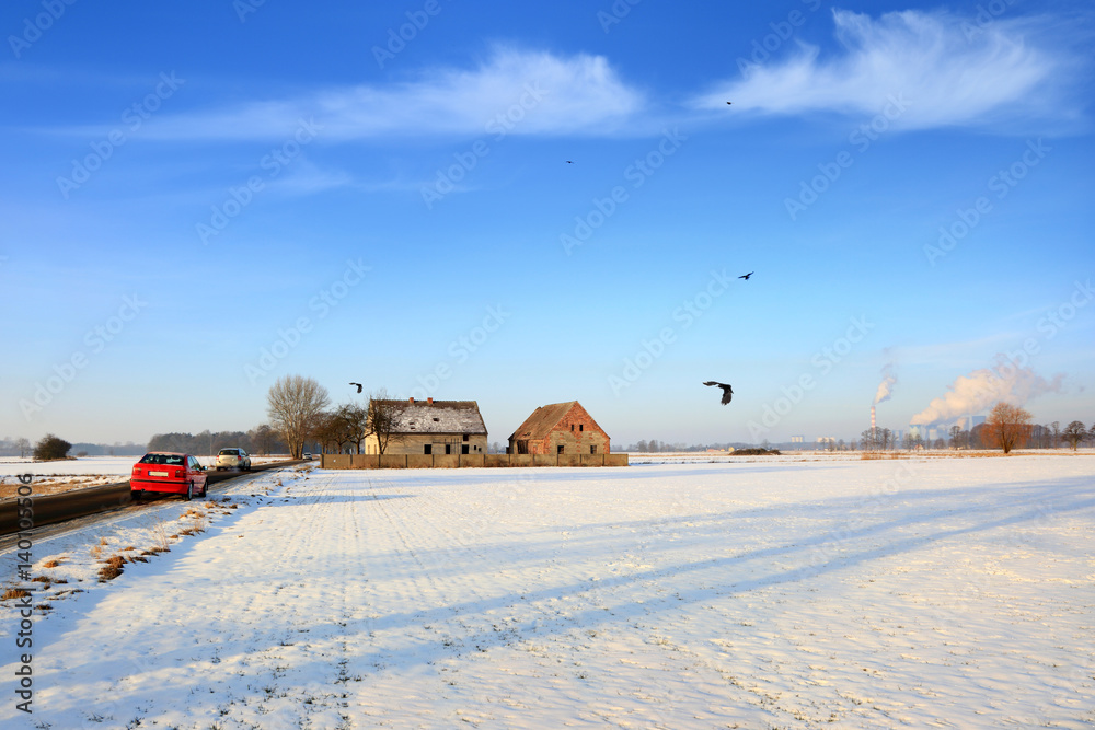 Fototapeta premium Krajobraz zimowy, samochody na drodze, elektrownia.