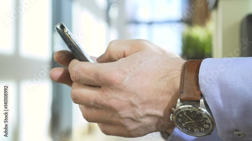 Close up on businessman's hands sms typing on smartphone app, profile, steadycam
