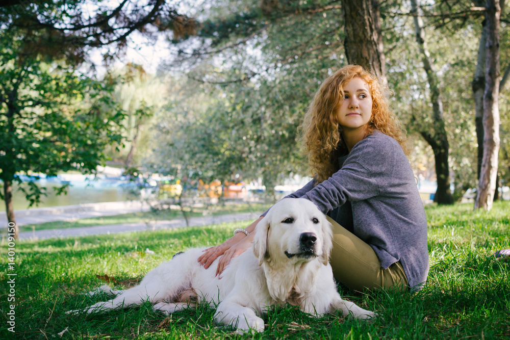 Young female sitting with labrador retriever dog in park Young female sitting with labrador retriever dog in park
