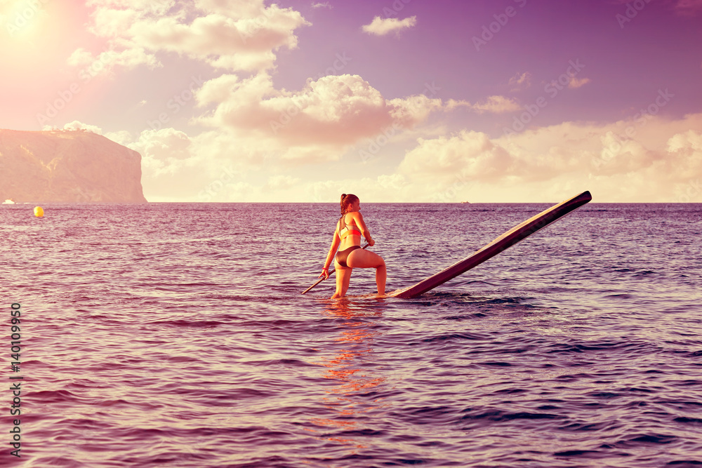 Naklejka premium SUP Stand up Surf girl with paddle