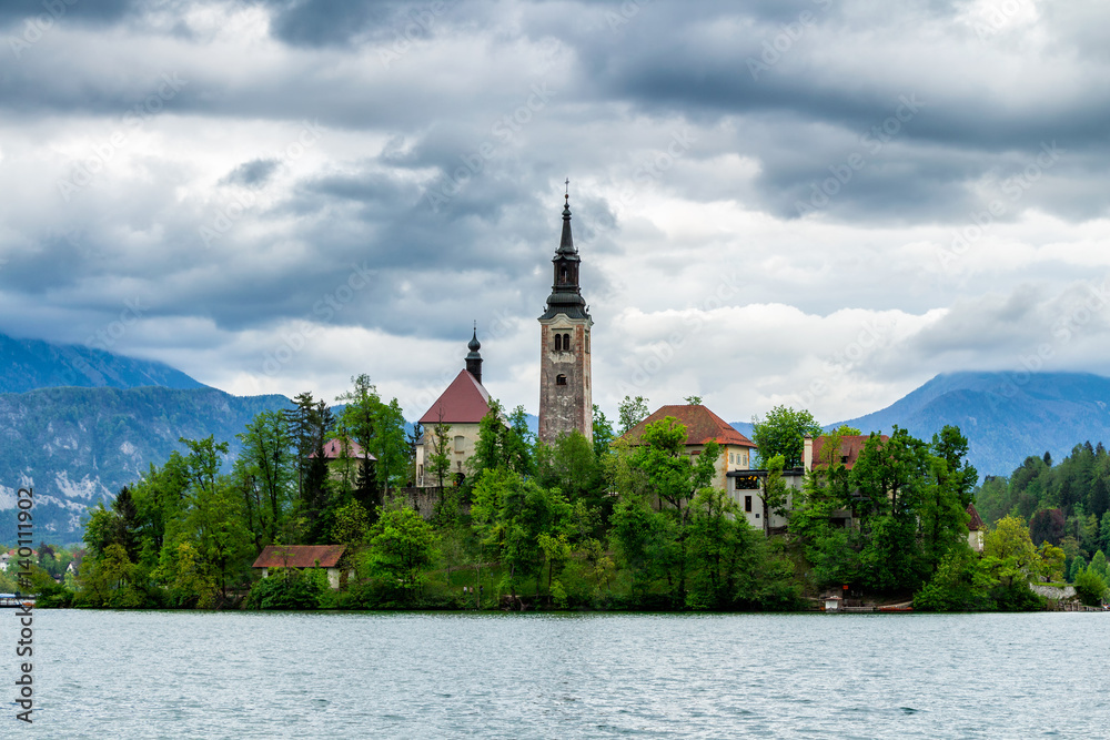 Lake Bled with St. Marys Church of Assumption on small island. Bled, Slovenia, Europe. Mountains and valley on background. Areal view from above.