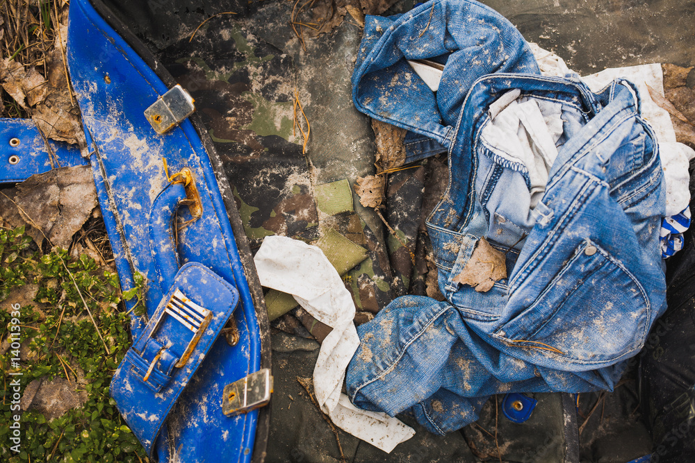 Dirty old denim jeans in broken old blue suitcase. Messy clothes  background. Horizontal color photography. Stock Photo | Adobe Stock