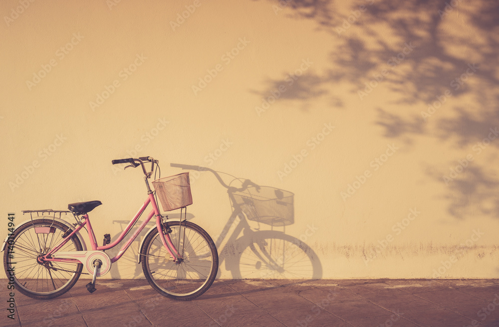 Bicycle parked at morning time beside the wall and shadow with area copy space