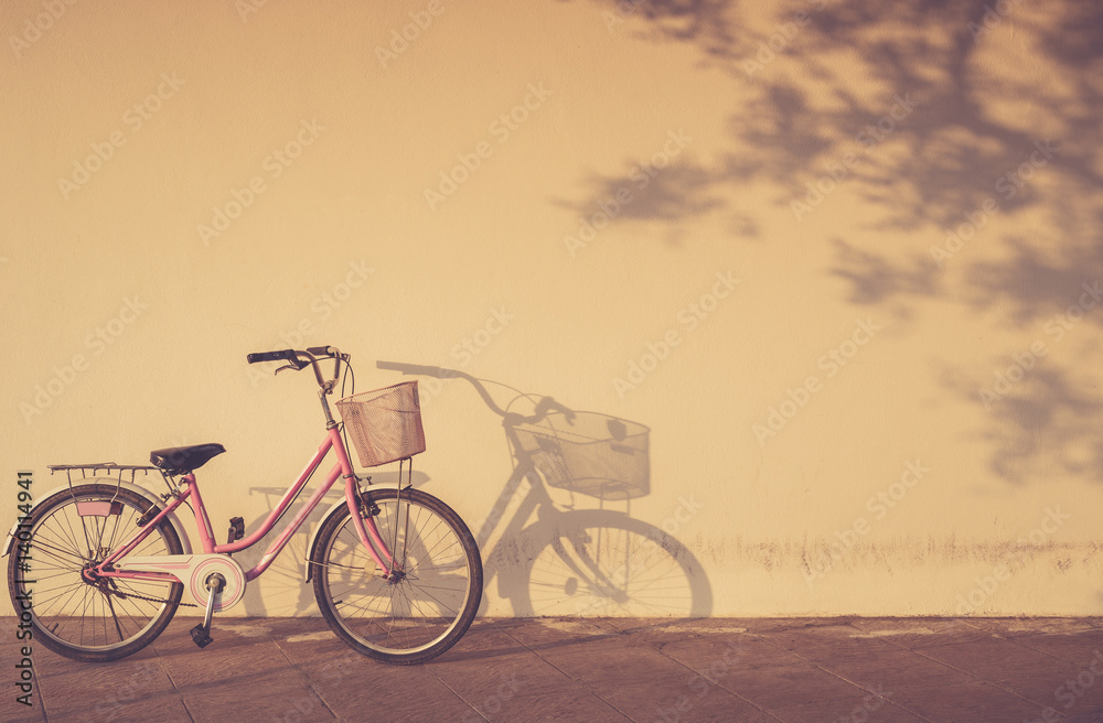 Fototapeta premium Bicycle parked at morning time beside the wall and shadow with area copy space