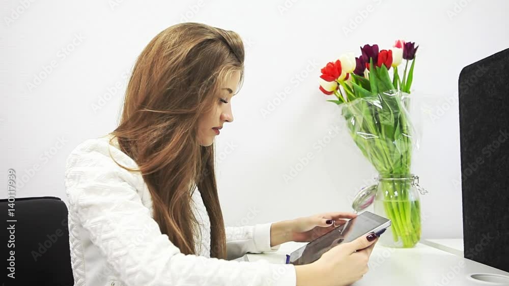 Beautiful young woman on the workplace using a digital tablet. Beautiful young woman on the workplace using a digital tablet.