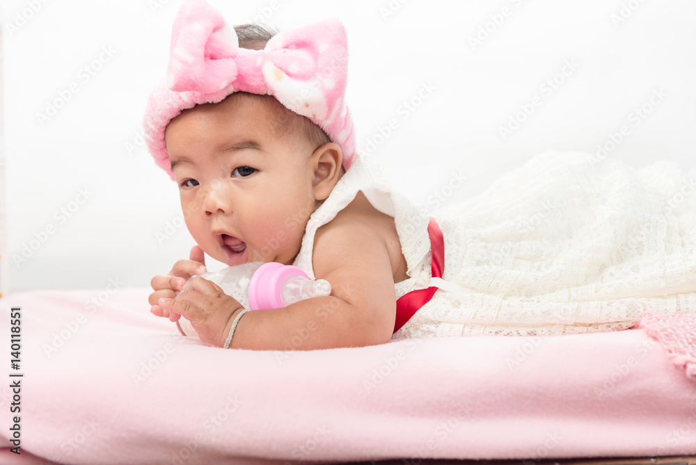happy laughing child lies with milk bottle on bed. happy laughing child lies with milk bottle on bed.