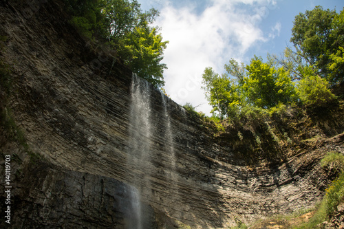 upward view of a waterfall in front of blue sky
