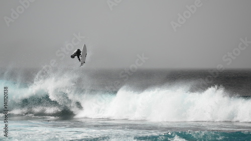 Surfer jumping on a wave