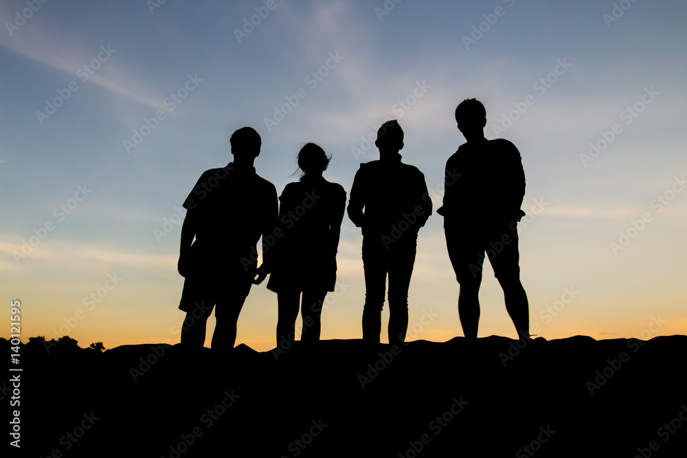 Silhouette of people posting during sunset