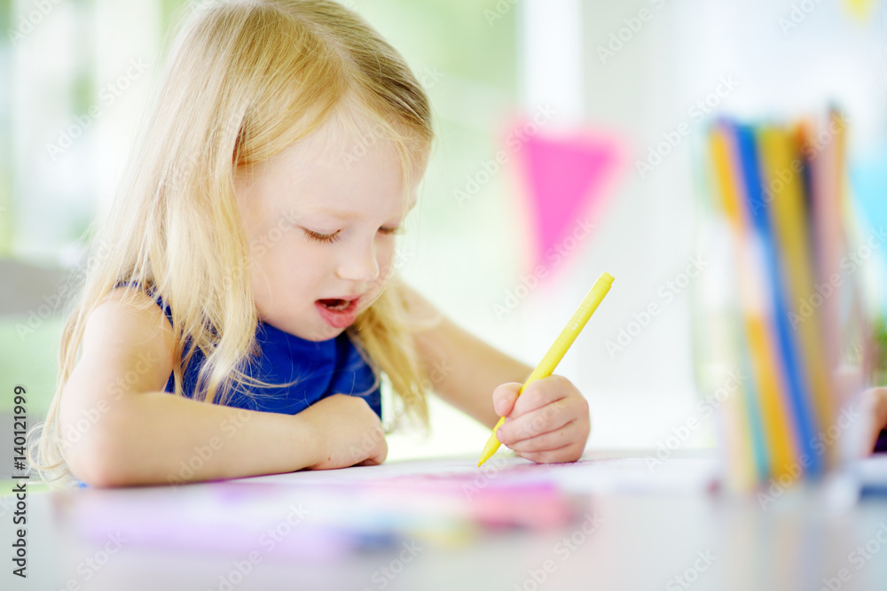 Cute little girl drawing with colorful pencils at a daycare. Creative kid painting at school Cute little girl drawing with colorful pencils at a daycare. Creative kid painting at school