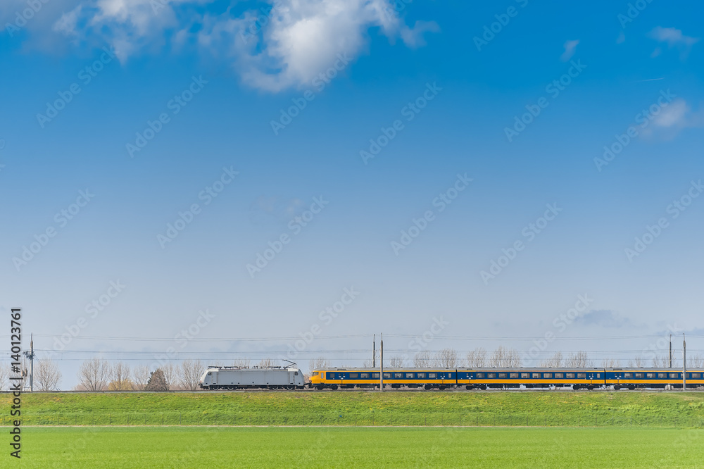 Passenger Train Moving along Green Field