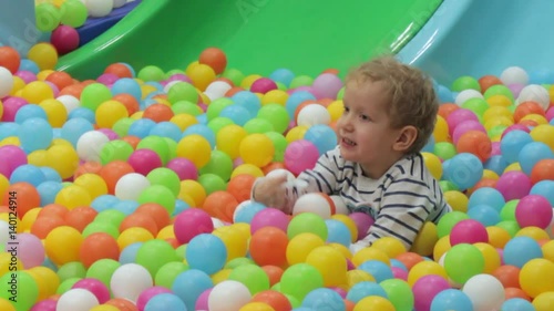 Boy playing with colored balls, playroom