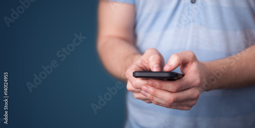 Young man holding smarthphone in hand