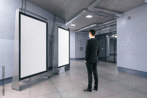 Man looking at blank whiteboards