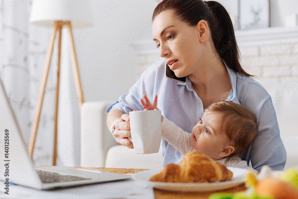 Busy dedicated lady sharing her morning with daughter Busy dedicated lady sharing her morning with daughter
